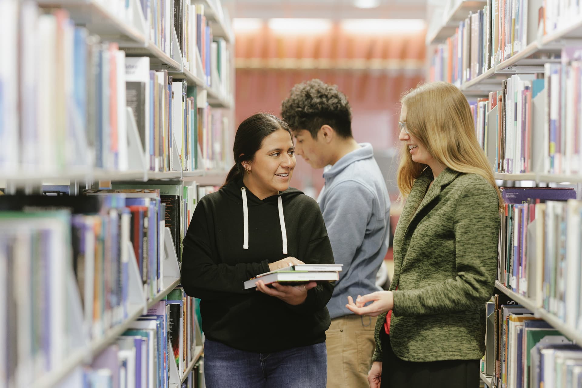 Librarian assisting students with books